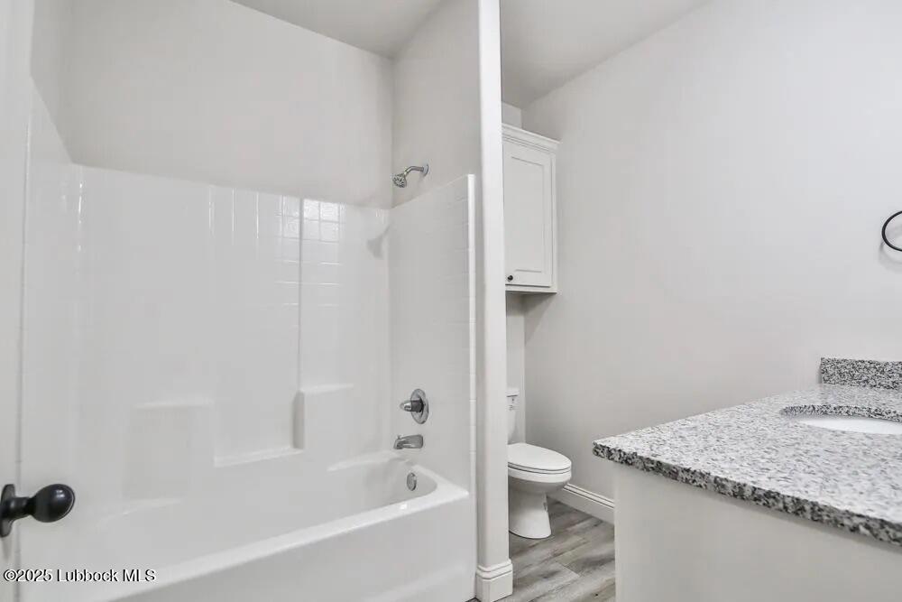 1602 102nd Street Lubbock, TX 79423 - Photo 11 of 16 a bathroom with a granite countertop sink toilet and shower