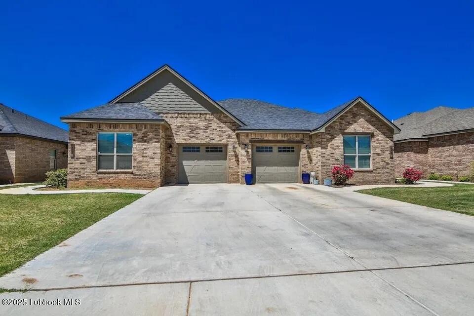 1602 102nd Street Lubbock, TX 79423 - Photo 2 of 16 a front view of a house with a yard and garage