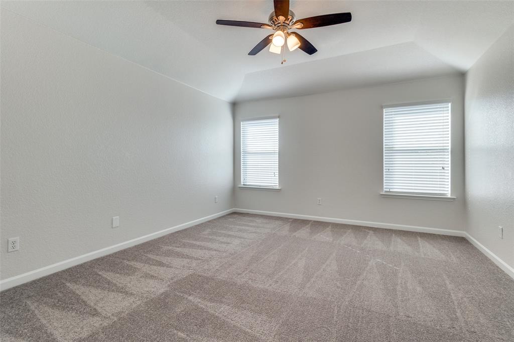 1257 Barrel Run Fort Worth, TX 76052 - Photo 13 of 26 Carpeted interior space featuring a tray ceiling with a ceiling fan, two windows with blinds, and light-colored walls