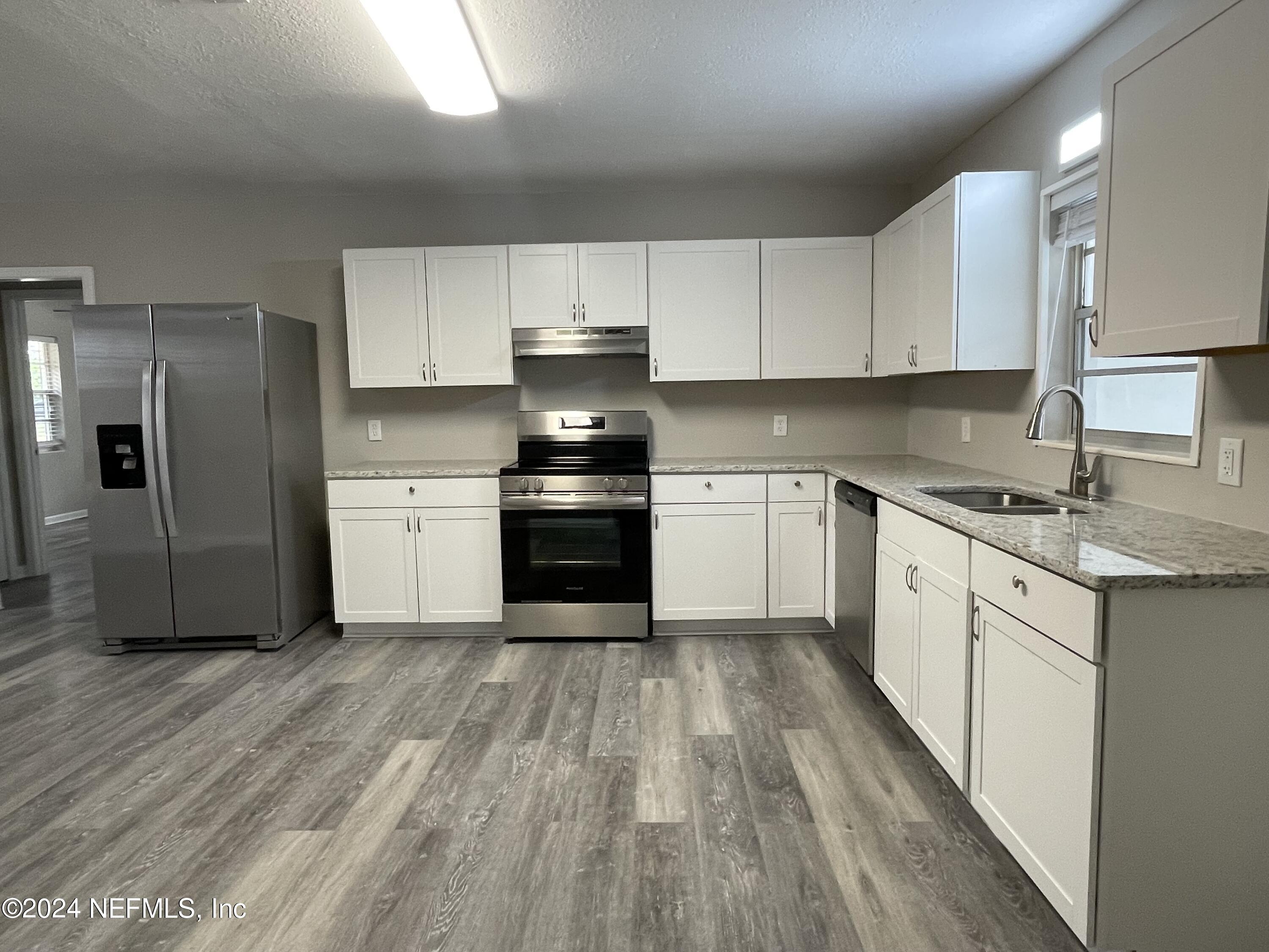 830 Gerona Road St. Augustine, FL 32086 - Photo 13 of 27 a kitchen with wooden floors and white appliances