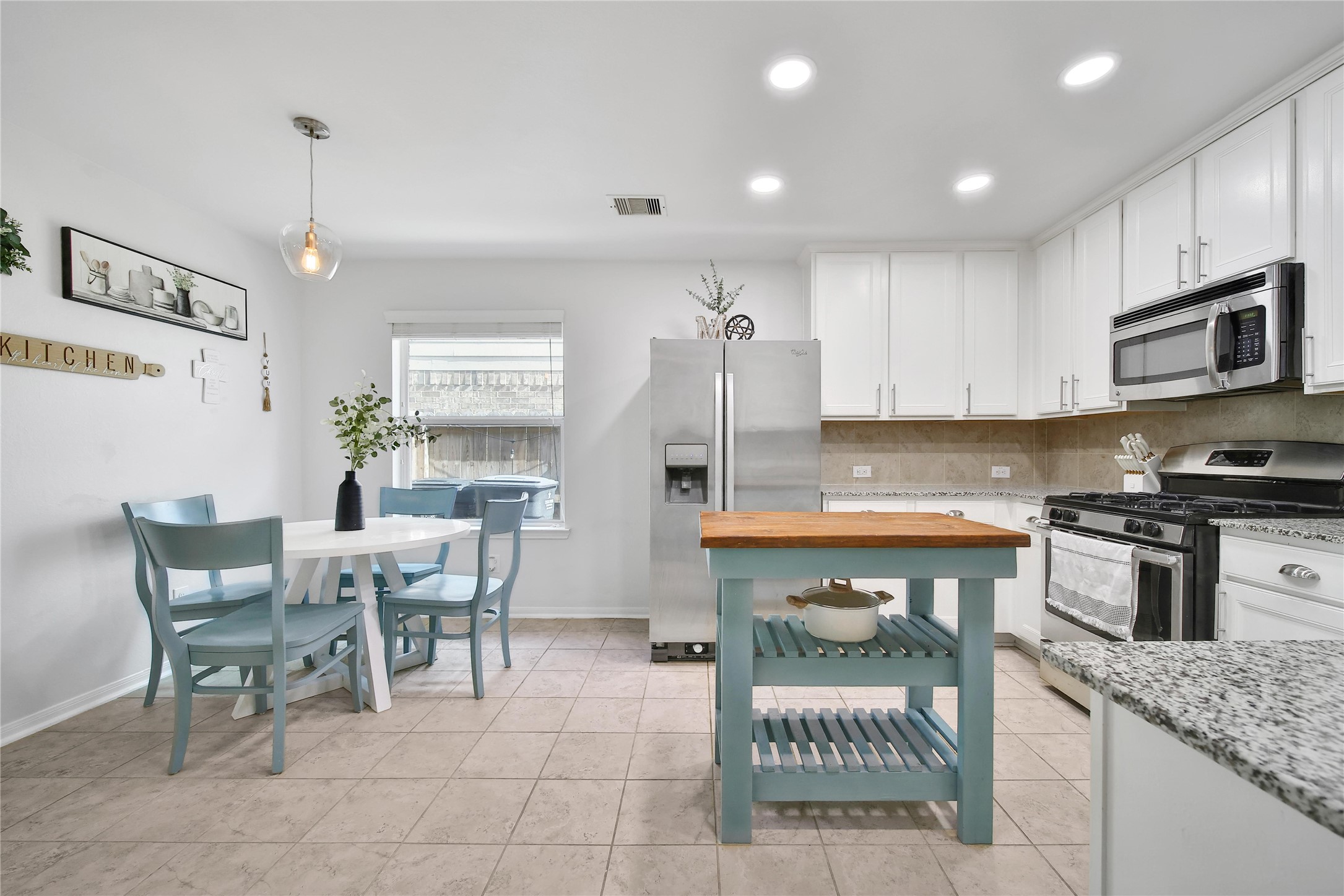 1279 Pinto Pass Alvin, TX 77511 - Photo 7 of 31 a kitchen with stainless steel appliances granite countertop a stove top oven a sink a dining table and chairs