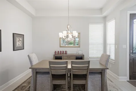 a living room with furniture a chandelier and a dining table