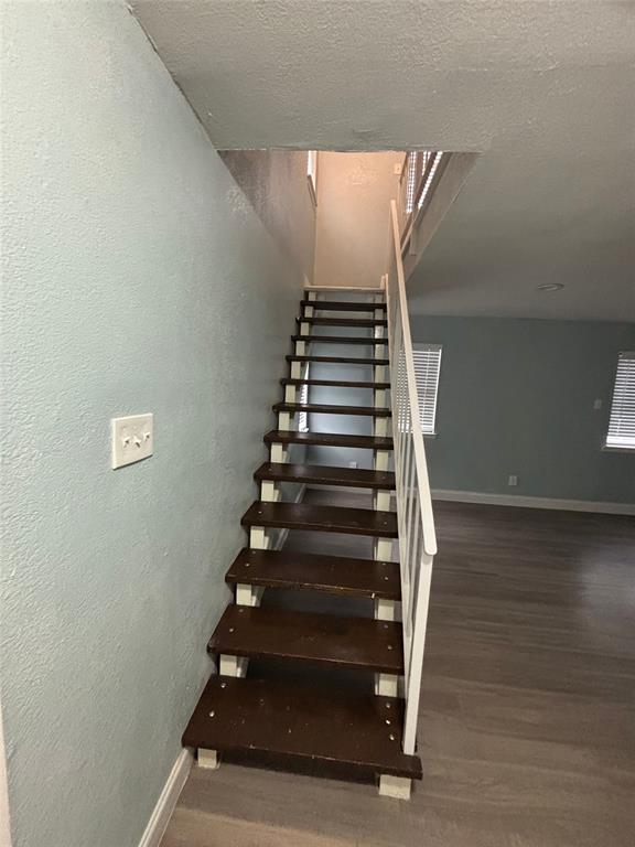 301 Rolston Road, Unit 315101 Irving, TX 75060 - Photo 10 of 12 Staircase featuring dark wood-finish treads and a white painted railing