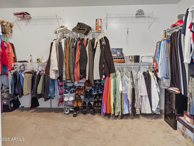 a view of walk in closet with clothes