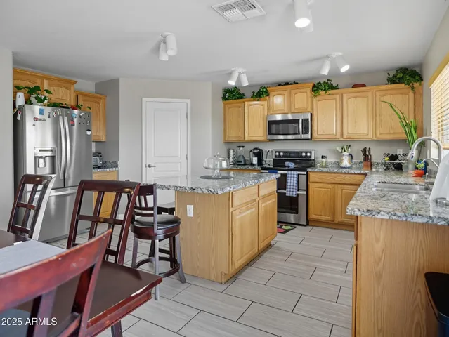 a kitchen with a table chairs sink and cabinets