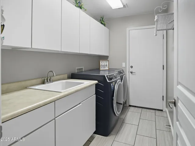 a utility room with sink dryer and washer