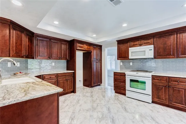 a kitchen with stainless steel appliances granite countertop a stove sink and cabinets