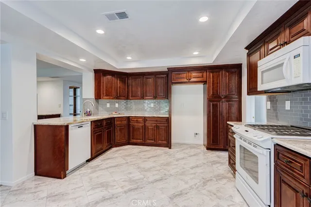 a large kitchen with stainless steel appliances granite countertop a stove refrigerator sink and cabinets