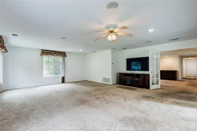 an empty room with windows and fireplace