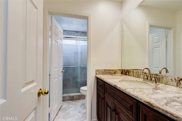 a bathroom with a granite countertop sink and a mirror