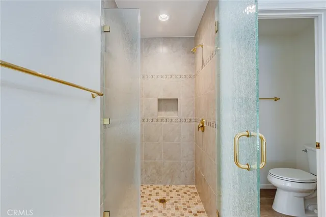 a bathroom with a granite countertop toilet a shower and a sink