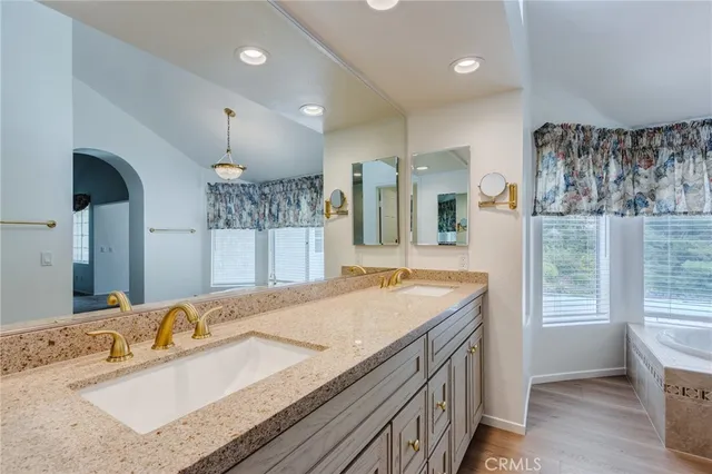 a bathroom with a granite countertop double vanity sink and a mirror
