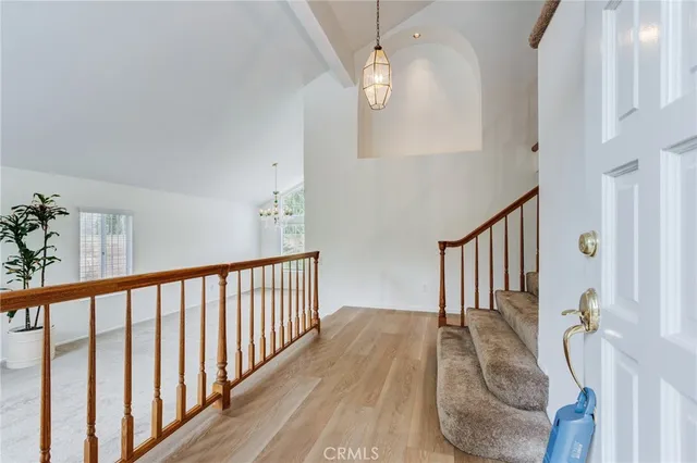 a view of a hallway with wooden floor and stairs