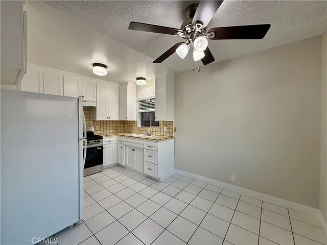 a kitchen with white cabinets and appliances