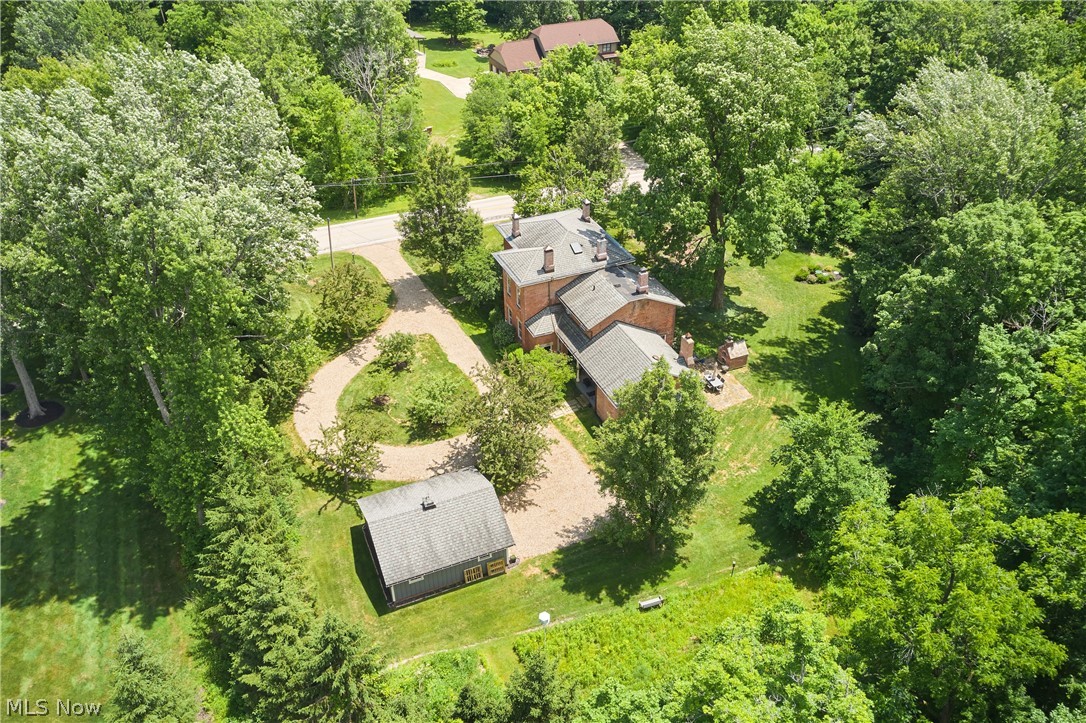 5046 Alger Road Richfield, OH 44286 - Photo 5 of 49 Brick residence with multiple rooflines, featuring a circular gravel driveway, detached auxiliary building, and extensive surrounding mature greenery