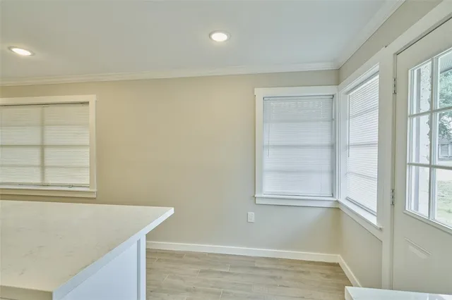 a view of empty room with window and wooden floor