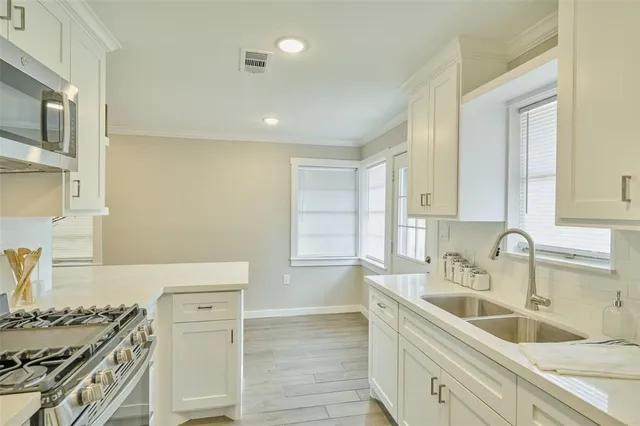 a kitchen with a sink stove top oven and cabinets