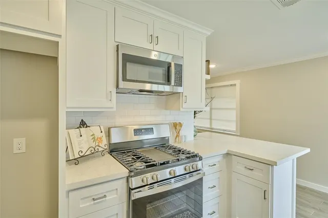 a kitchen with stainless steel appliances white cabinets and stove