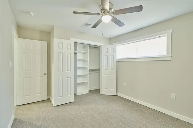 an empty room with closet and windows