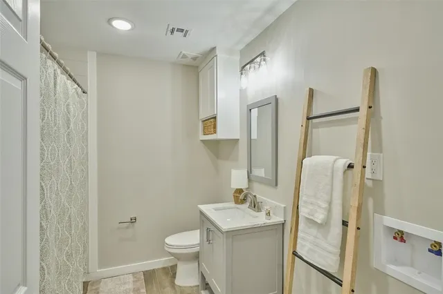 a bathroom with a granite countertop sink toilet and shower