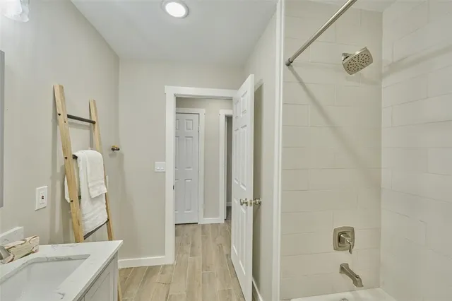 a bathroom with a granite countertop sink a toilet and shower