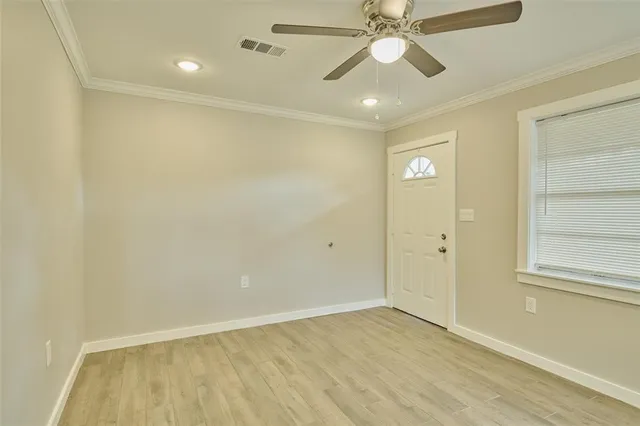 an empty room with a ceiling fan and window