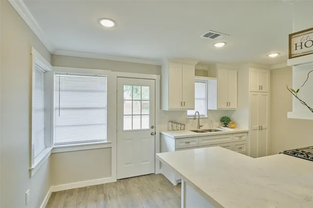 a kitchen with a sink a window and cabinets