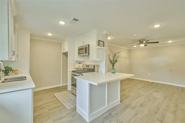 a view of a kitchen center island and stainless steel appliances