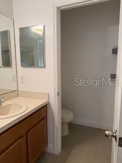 a bathroom with a granite countertop sink a toilet and mirror