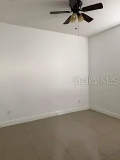 an empty room with a ceiling fan and window