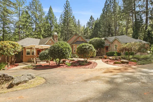 a front view of a house with a yard and potted plants
