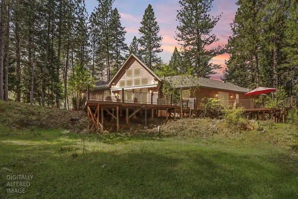 a view of a house with backyard and sitting area