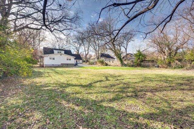 a view of a yard with a house and large trees