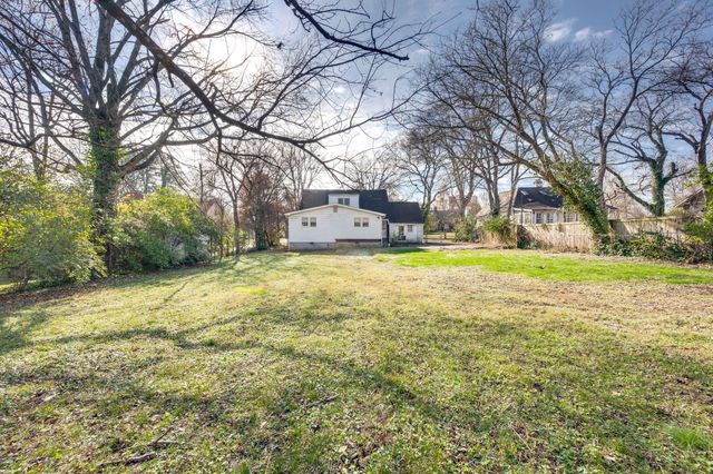a view of a yard with a house and large trees