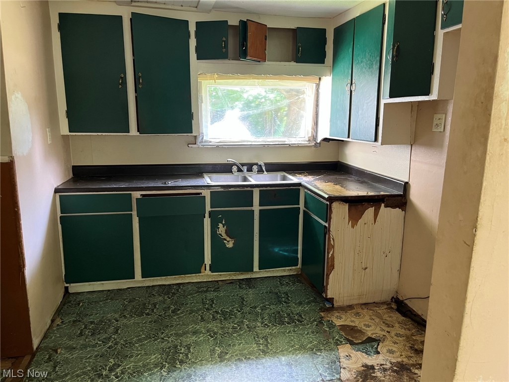 7465 North Ridge Road Madison, OH 44057 - Photo 8 of 20 Kitchen featuring green cabinets and sink