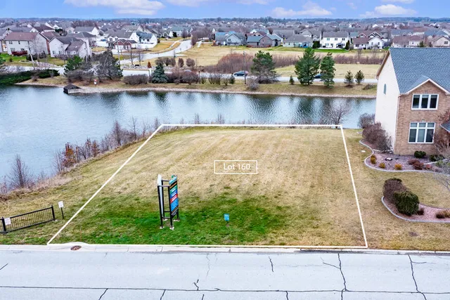 an aerial view of residential houses with outdoor space and lake view