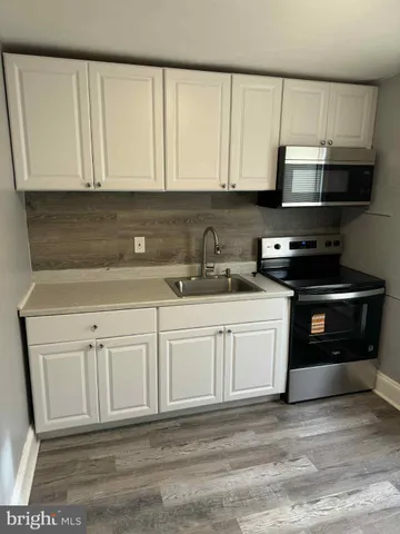 a kitchen with granite countertop white cabinets and stainless steel appliances