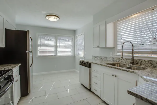 a kitchen with a sink a refrigerator and window