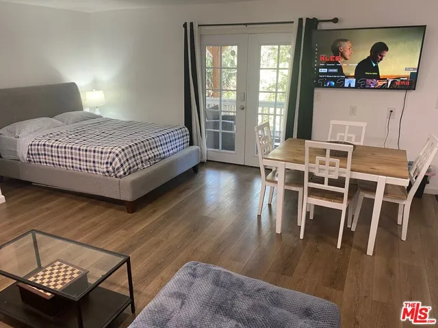 a bedroom with a bed and a dresser next to a window