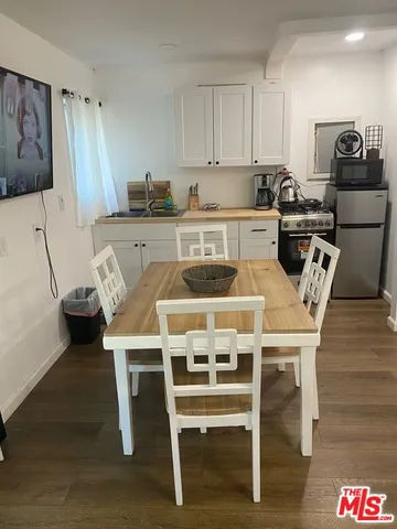 a kitchen with a table chairs a sink dishwasher and cabinets
