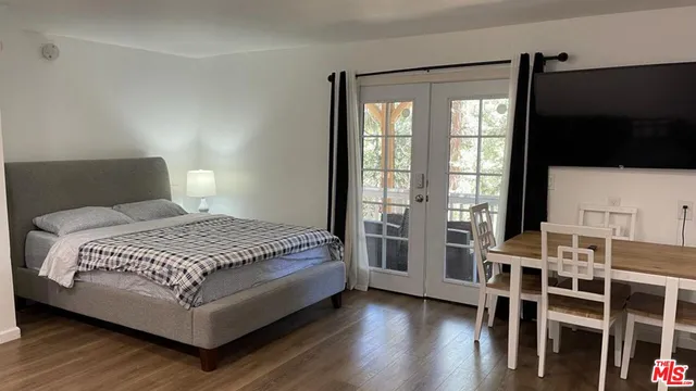 a bedroom with a bed and a flat tv screen on the dresser