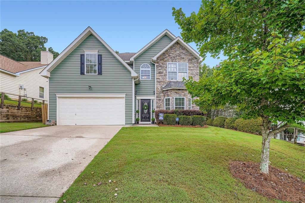 a front view of a house with a yard and garage