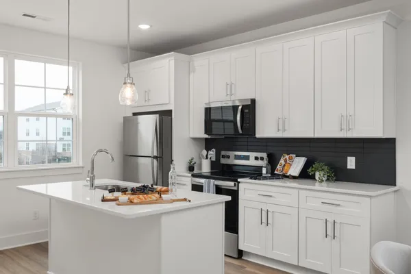 a kitchen with stainless steel appliances granite countertop a sink a stove and a refrigerator