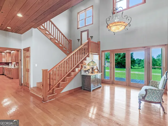 a view of a livingroom with furniture wooden floor windows and a chandelier