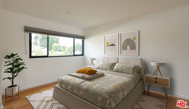 a bedroom with a bed and a potted plant