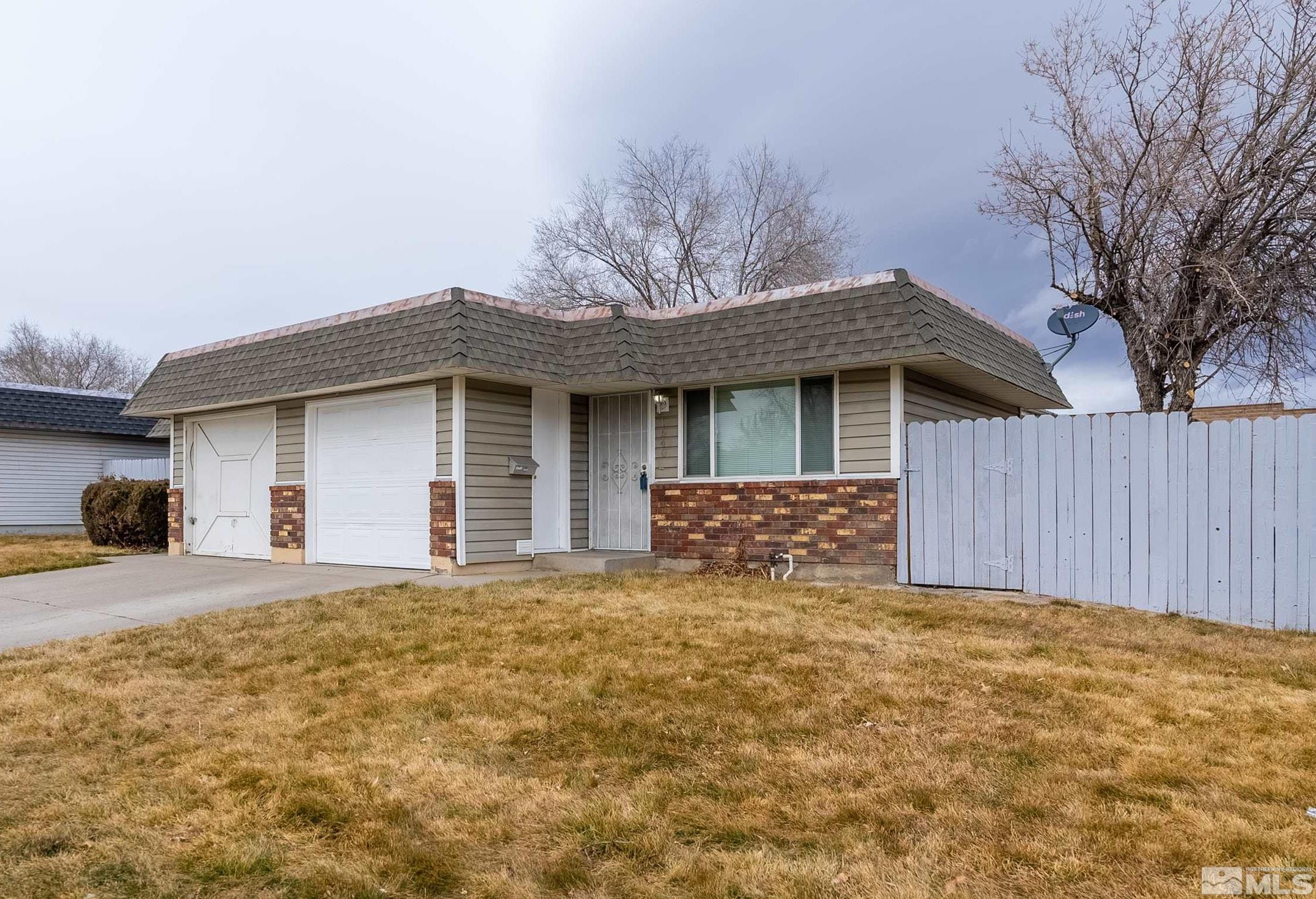 a front view of house with yard and trees in the background