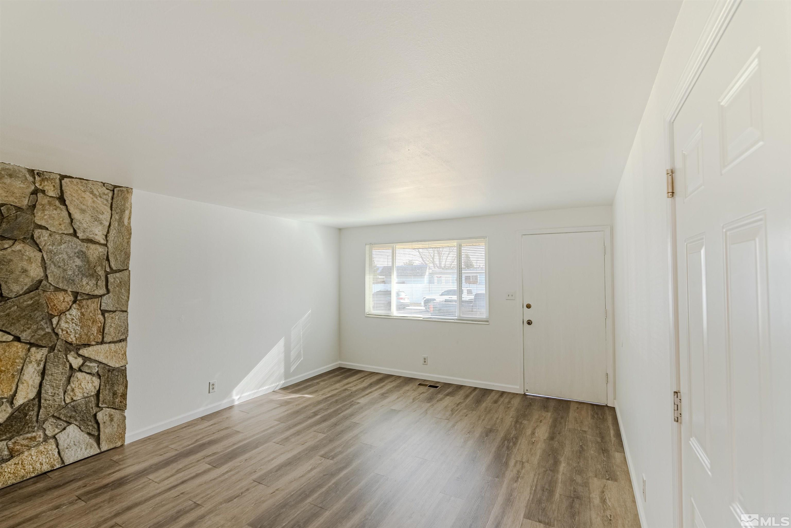 1640 Gault Way Sparks, NV 89431 - Photo 4 of 15 an empty room with wooden floor and windows