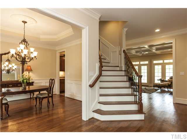 913 Keith Road Wake Forest, NC 27587 - Photo 3 of 25 Entering The Spacious Foyer You Will See This Beautiful Curved Staircase With Iron Details. The Dining Room And Bar Are On Your Left. Not Pictured is the Formal Lving On Your RIght. The Family Room Is Pictured In The Background And Open To The Kitchen