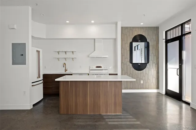 a view of kitchen with stainless steel appliances granite countertop a stove top oven a sink and a refrigerator