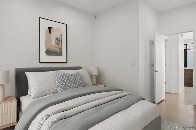 a bedroom with a bed and a painting on the wall